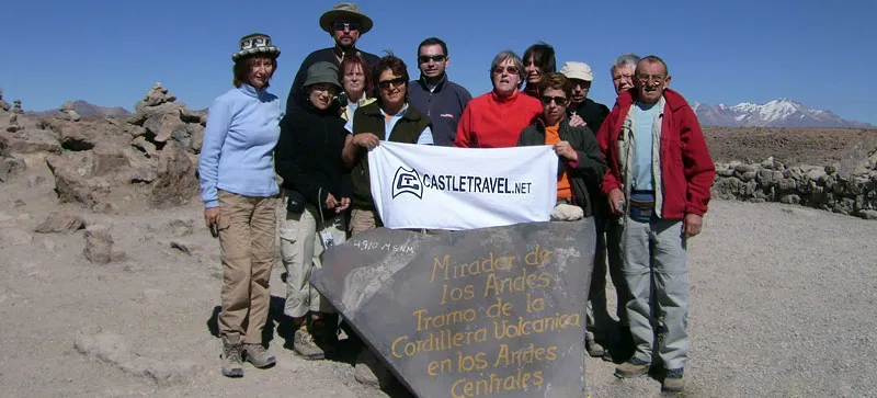 Groupe de voyageurs à un point haut du sud péruvien, marqueur de pierre